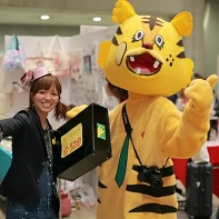 Two people - one with a tiger suit - promote their booth by walking around.