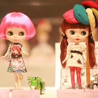 A Blythe doll in a colorful Tokidoki dress walking Bastardino the cactus dog (left) and a Blythe doll by Naito Yamada (やまだないと) displaying a manga artist wearing many stereotypical berets.