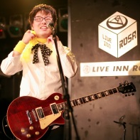 ヒット君 (Hit-kun) of 装置メガネ (Sōchi Megane) adjusting his new bow which 'seems to be a little to big'.