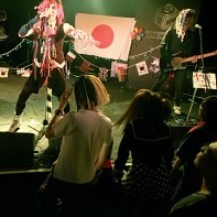 マイナス人生オーケストラ (Minus Jinsei Orchestra) performing in front of the fascinated audience.
