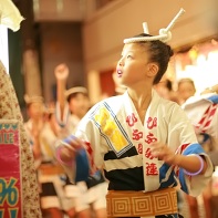 A young girl in a traditional yukata dancing through the commercial neighborhood of Shimokita.
