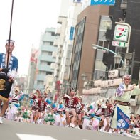 Note the big crowd of spectators at either sides of the street where the dance groups are performing.