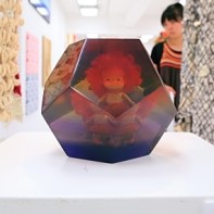 A large plastic dodecahedron with a doll inside.