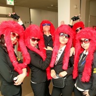 A group of performers dressed in black suits with red faux fur wigs at the Chiyoda Art Festival 2011.