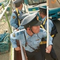 Japanese policemen finally arrest the exhausted anti-nuclear protester.