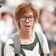 Japanese guy wearing glasses grimacing.