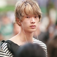 Japanese boy with fair hair throwing a wary glance.