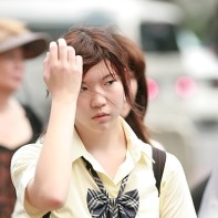 A good-looking Japanese girl running her hand through her hair.