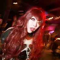 A long-haired girl wearing colored contact lenses dancing at the Artism event.