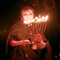 Mars Medicis Mephistopher beginning his performance with carrying a Hanukkah menorah candelabrum.