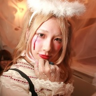 A blond Japanese girl wearing an elaborate Halloween costume.