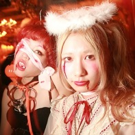 Two Japanese girls with costumes, one scary, one cute, at the Trump Room.