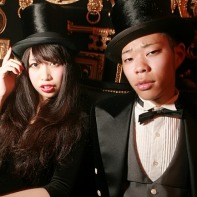 A Japanese couple in very formal clothes, with him wearing a morning dress plus top hat.