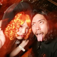 A Japanese couple posing for the camera, with the guy sticking out his tongue.