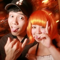 A Japanese guy posing with his orange-haired girlfriend.