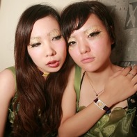 Two girl DJs in green dresses relaxing after their show.