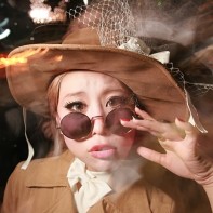 Japanese girl in a brown corduroy coat with matching hat.