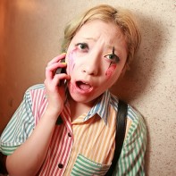 A Japanese girl busy on her cell phone takes a moment for a picture.
