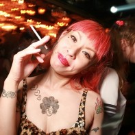 Tattooed Japanese redhead smiling and smoking.